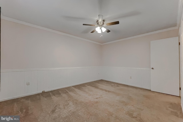 carpeted spare room featuring ceiling fan and ornamental molding