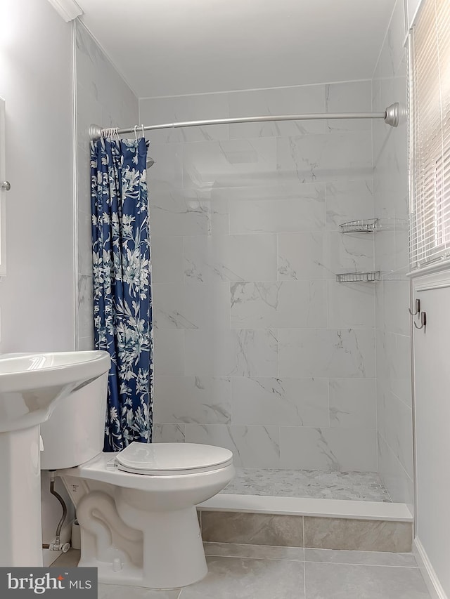 bathroom with tile patterned floors, toilet, and curtained shower