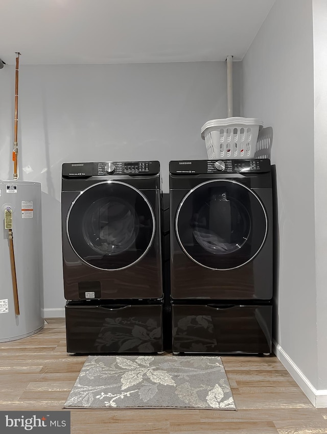 laundry area featuring gas water heater, independent washer and dryer, and light hardwood / wood-style flooring