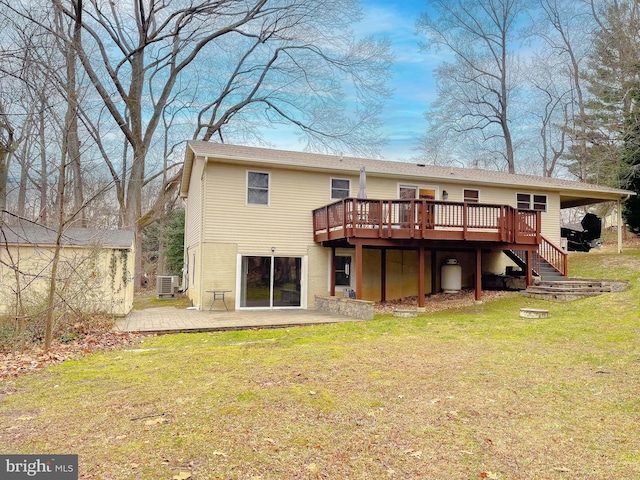 back of property featuring a deck, a patio area, and a lawn