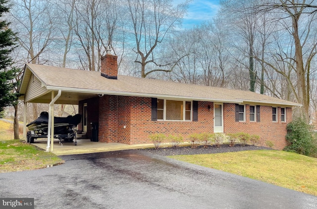 single story home with a front lawn and a carport