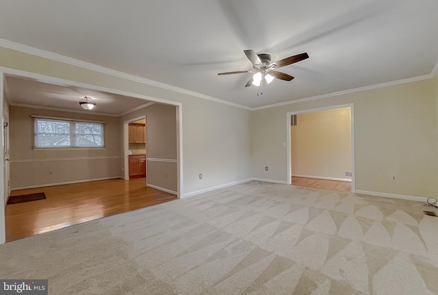 spare room featuring light colored carpet, ceiling fan, and ornamental molding