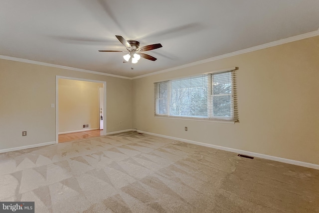 unfurnished room featuring light colored carpet, ceiling fan, and crown molding