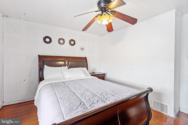 bedroom featuring light hardwood / wood-style flooring, ceiling fan, and crown molding