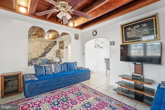 tiled living room with ceiling fan, beamed ceiling, and wood ceiling