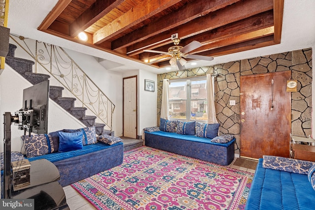 living room with ceiling fan, beamed ceiling, and wooden ceiling