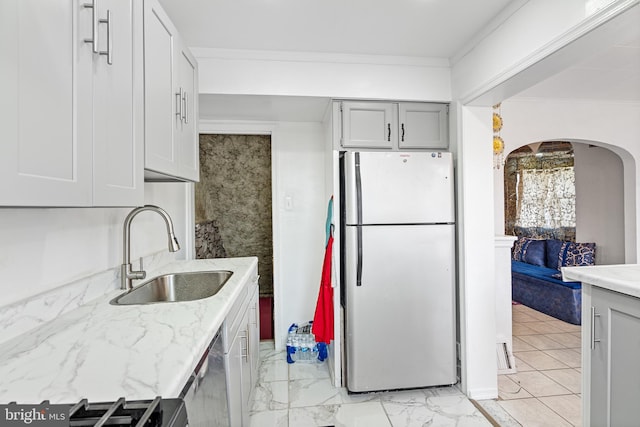 kitchen with crown molding, sink, white fridge, and stainless steel dishwasher