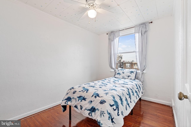 bedroom with ceiling fan, dark hardwood / wood-style flooring, and ornamental molding