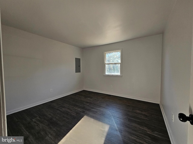 empty room featuring electric panel and dark hardwood / wood-style floors