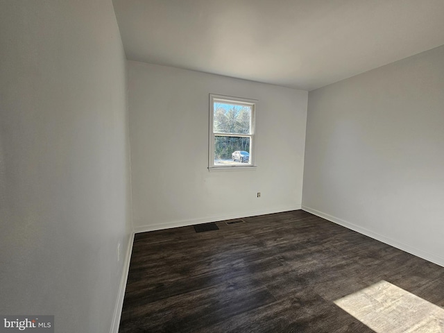 unfurnished room featuring dark hardwood / wood-style flooring