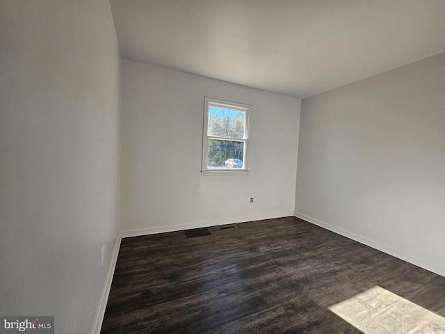 unfurnished room with dark hardwood / wood-style flooring