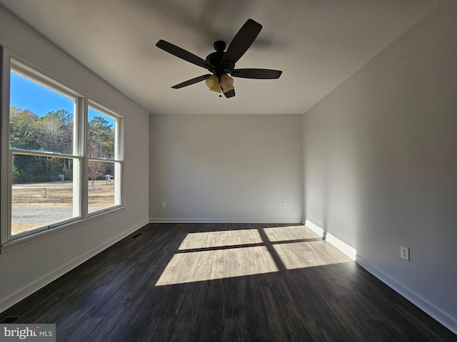 spare room featuring ceiling fan and dark wood-type flooring