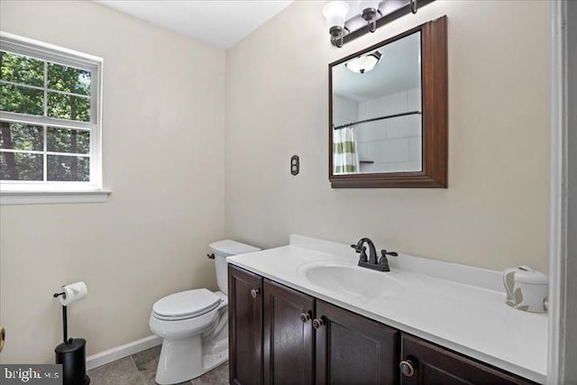 bathroom featuring tile patterned flooring, vanity, a shower with shower curtain, and toilet