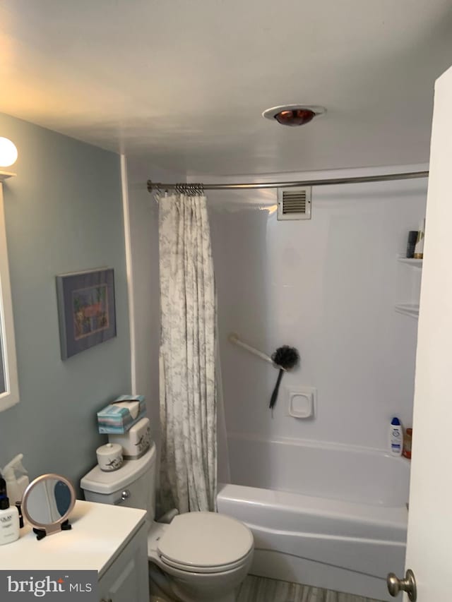 full bathroom with vanity, shower / tub combo, and toilet