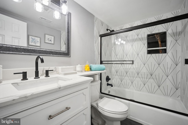 full bathroom featuring vanity, toilet, and shower / bath combination with glass door