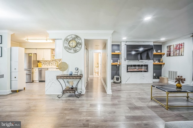 living room featuring light hardwood / wood-style floors and ornamental molding