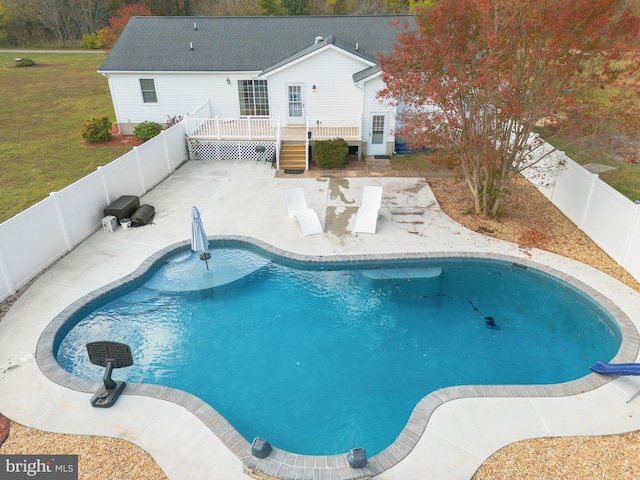 view of swimming pool with a wooden deck and a yard