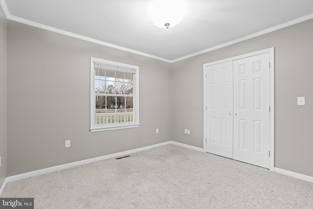 unfurnished bedroom featuring carpet, a closet, and crown molding