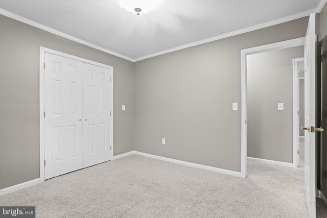 unfurnished bedroom with a closet, carpet flooring, and crown molding