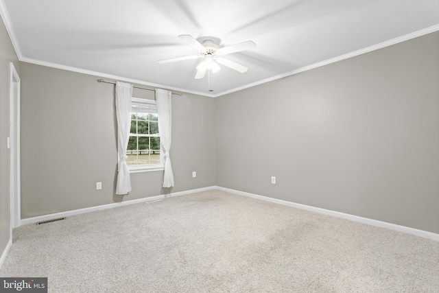 carpeted empty room featuring ceiling fan and crown molding