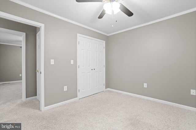 unfurnished bedroom featuring ceiling fan, light colored carpet, and crown molding