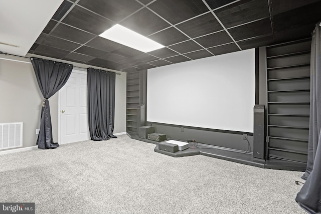 home theater room featuring carpet floors and a drop ceiling