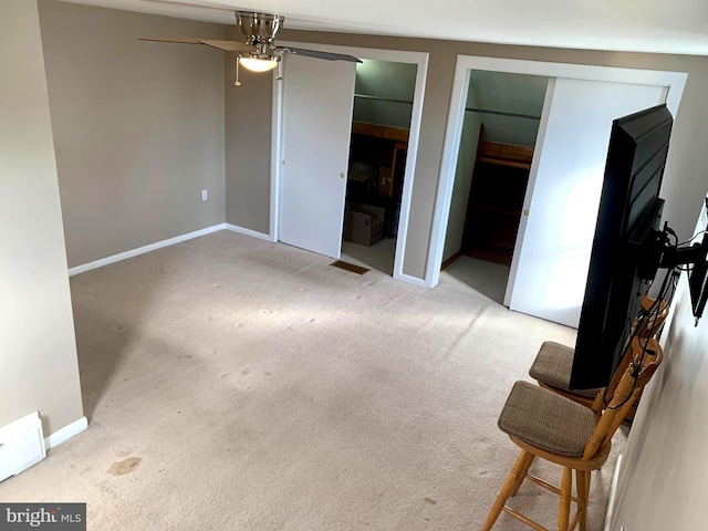 unfurnished bedroom featuring ceiling fan, light carpet, and a closet