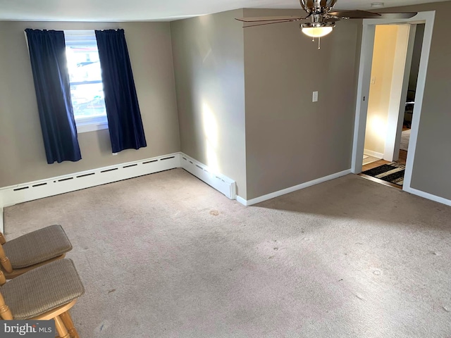 empty room with carpet flooring, ceiling fan, and a baseboard radiator