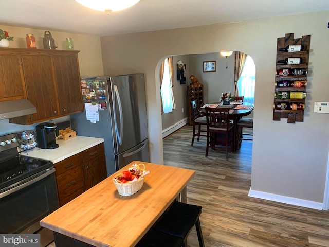 kitchen with stainless steel appliances, a baseboard radiator, and hardwood / wood-style flooring