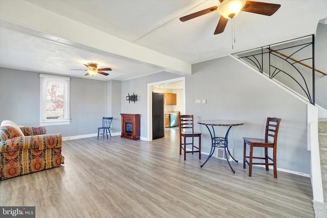 living room featuring wood-type flooring and ceiling fan