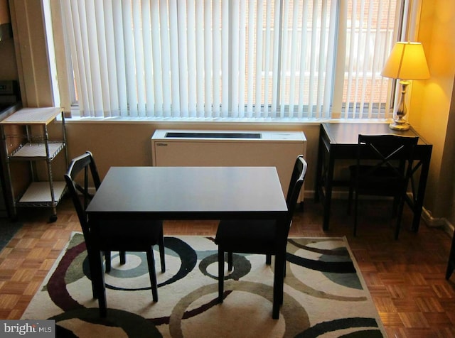 dining space with dark parquet flooring