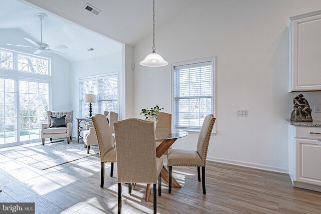 dining room with ceiling fan, high vaulted ceiling, and light hardwood / wood-style flooring