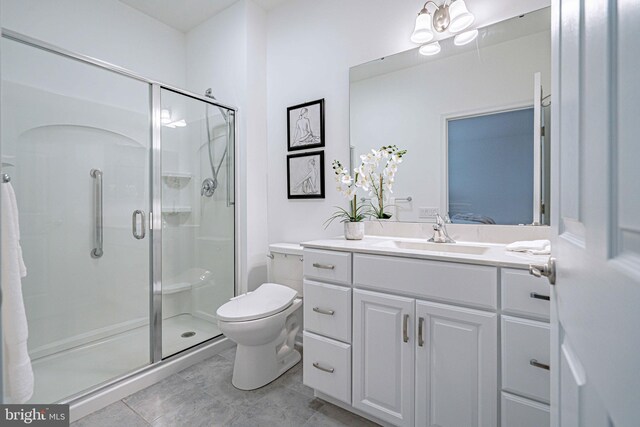 bathroom featuring tile patterned floors, vanity, toilet, and walk in shower