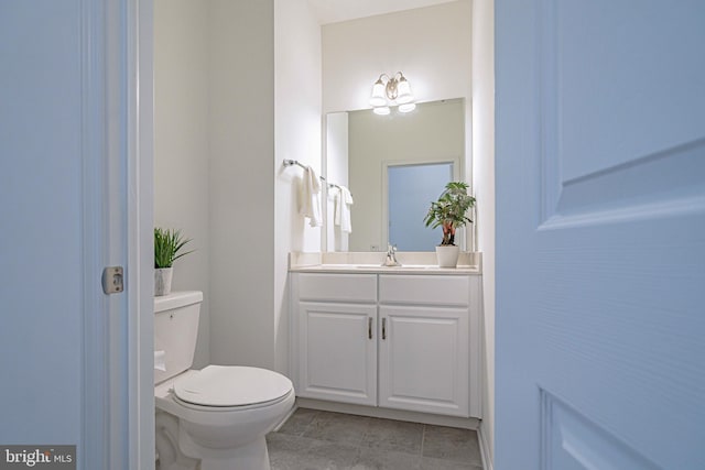 bathroom featuring tile patterned flooring, vanity, and toilet