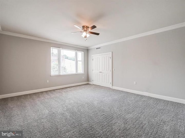 carpeted empty room with ceiling fan and ornamental molding