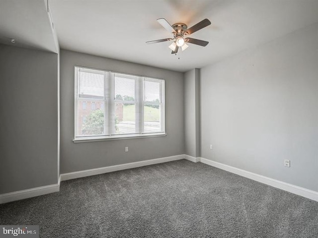 unfurnished room featuring ceiling fan and dark carpet