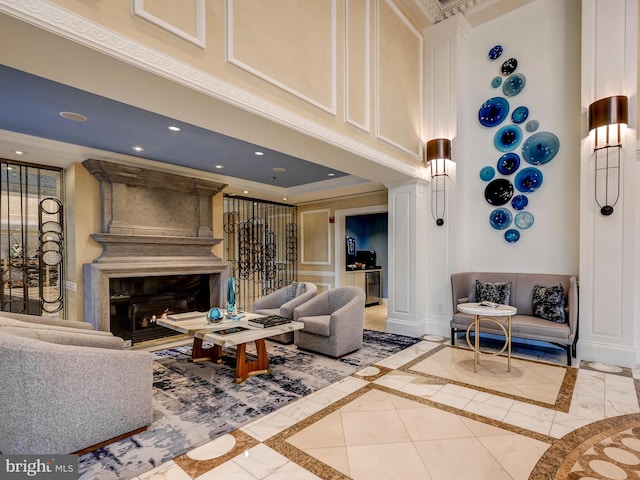 living room with a high ceiling, ornamental molding, and a premium fireplace