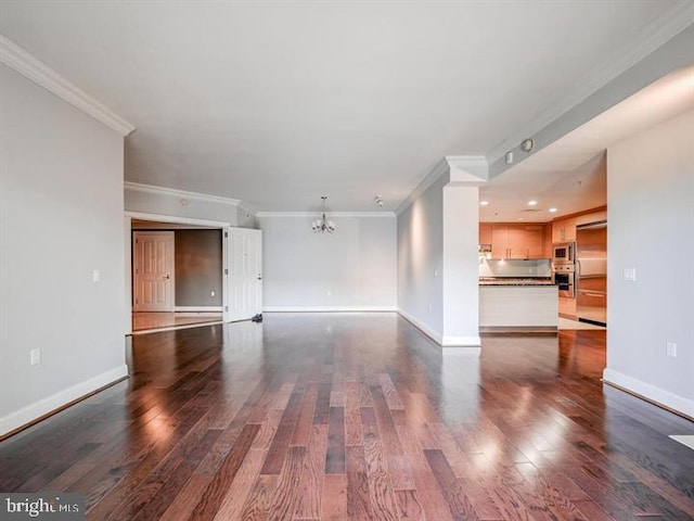 unfurnished living room with a chandelier, dark hardwood / wood-style flooring, and ornamental molding