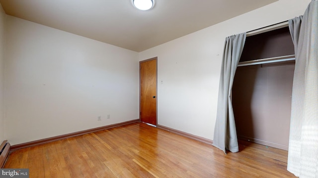 unfurnished bedroom with light hardwood / wood-style flooring and a closet