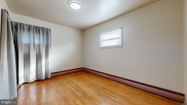 spare room featuring hardwood / wood-style floors and a baseboard radiator