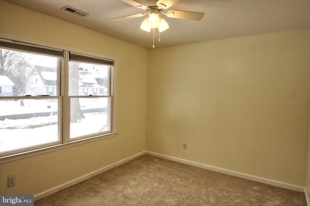 carpeted spare room featuring ceiling fan