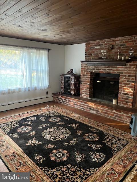 living room with a fireplace, hardwood / wood-style flooring, a baseboard heating unit, and wood ceiling