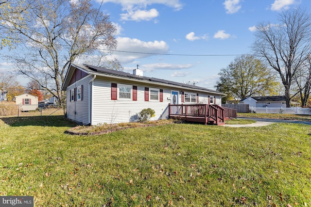 rear view of house featuring a lawn and a wooden deck