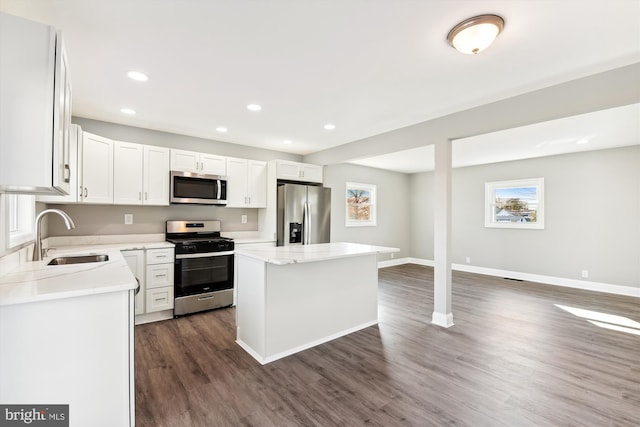 kitchen featuring a center island, sink, stainless steel appliances, dark hardwood / wood-style flooring, and white cabinets