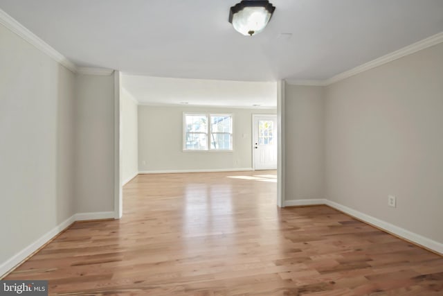 spare room featuring crown molding and light hardwood / wood-style flooring