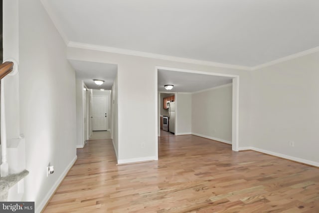 spare room with crown molding and light wood-type flooring