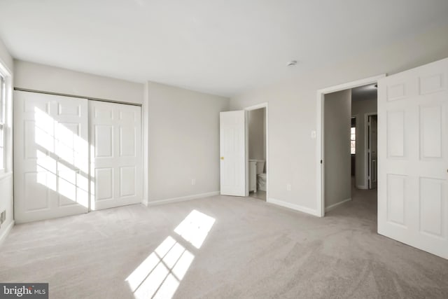 unfurnished bedroom featuring light carpet and a closet