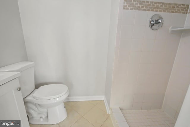 bathroom featuring tiled shower, tile patterned flooring, vanity, and toilet