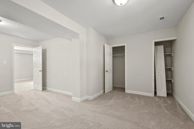 unfurnished bedroom featuring a closet and light colored carpet