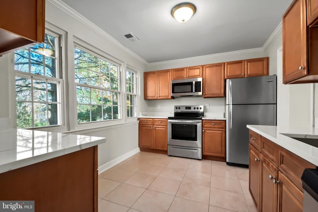 kitchen with light tile patterned flooring, ornamental molding, and appliances with stainless steel finishes